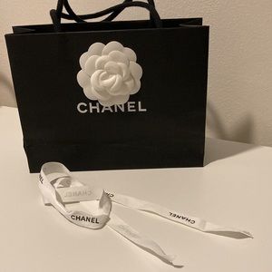 Black Chanel shopping bag with ribbon and Camellia